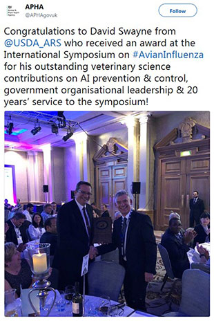 David Swayne tweet above a photo of himself shaking Ian Brown's hand. The Tweet reads, 'Congratulations to David Swayne from @USDA_ARS who received an award at the International Symposium on #Avianinfluenza for his outstanding veterinary science contributions on AI prevention and control, government organisational leadership and 20 years' service to the symposium.'