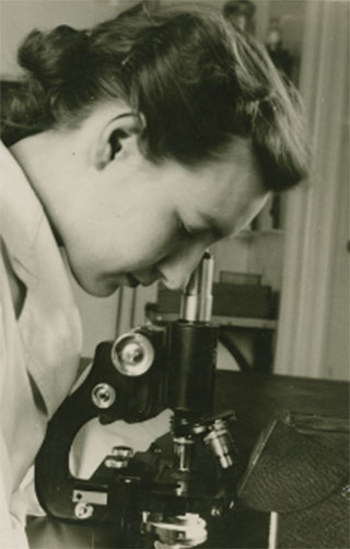 Connie M. Ford looking down a microscope.