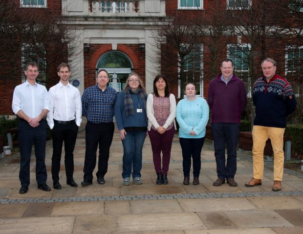 Five gentlemen and three ladies standing in front of APHA Weybridge