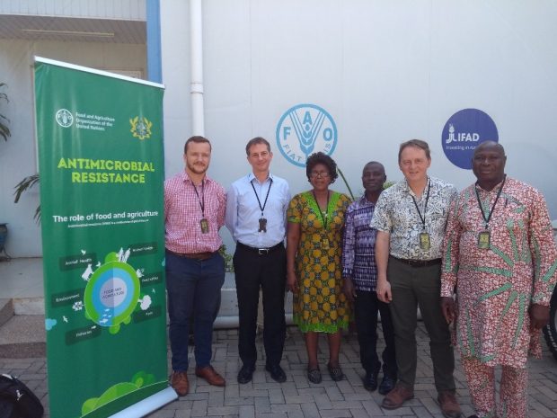 Five gentlemen and one lady standing in front of a pull-up banner sign to their left saying, Antimicrobial Resistance, the role of food and agriculture.