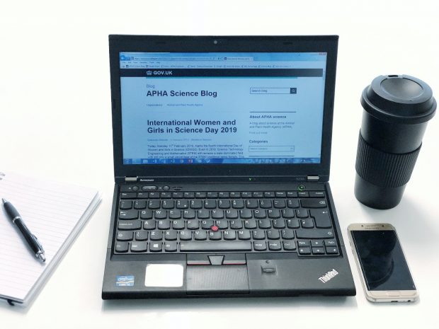 Picture of a laptop showing the APHA blog on screen, along with a coffe cup, mobile phone, pad and pen