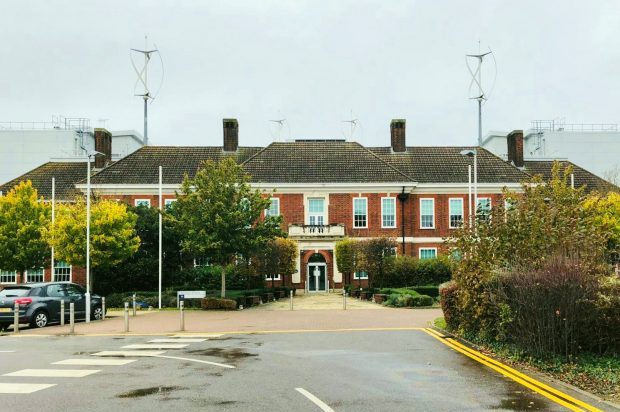 Image of a bending road leading to an large, red bricked building