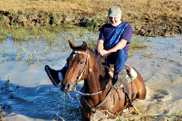 Image of Phil Jones riding a horse through water