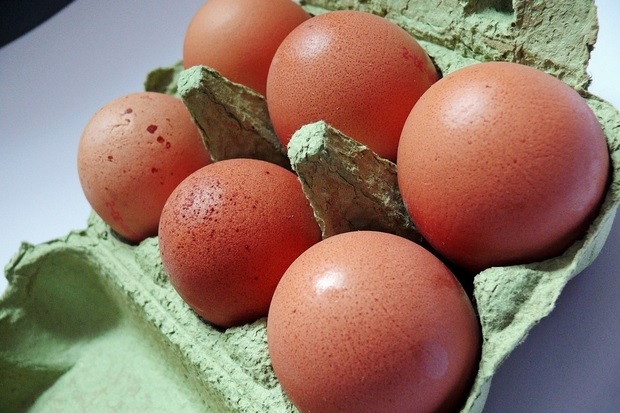 Image of six brown eggs in a green egg box.