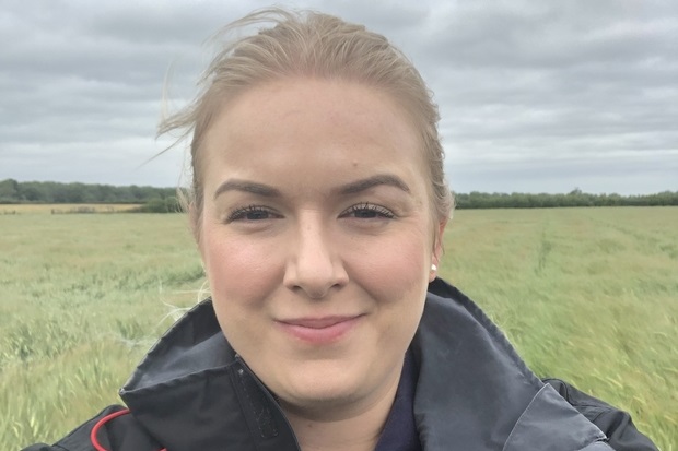 Image of Laura Chapman in a field. only her head is showing.