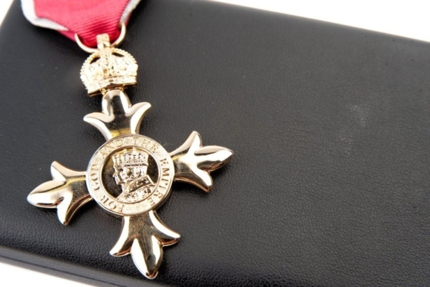 Image of a gold medal with the words 'For God and the Empire' written on it. The medal has a red ribbon and is sitting on a black box.