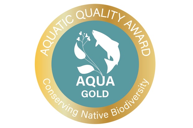 Logo: turquoise inner circle showing the outline of a fish and a plant in white with the words 'APHA GOLD' contained within an outer gold circle with the words 'AQUATIC QUALITY AWARD, Conserving Native Biodiversity' in white lettering.