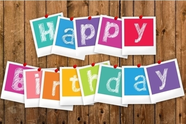 Letters spelling out the words 'happy birthday' pinned to a wooden background.