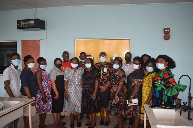 Image of 15 individuals posing for a group photograph, wearing face masks