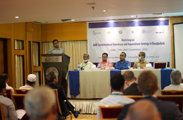 Image of a male presenting in front of an AMR banner with a panel of four other male colleagues