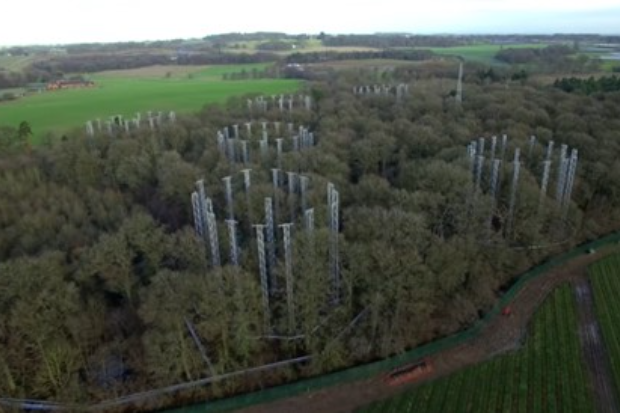 Image of some trees, taken from a drone, with circular structures rising through them
