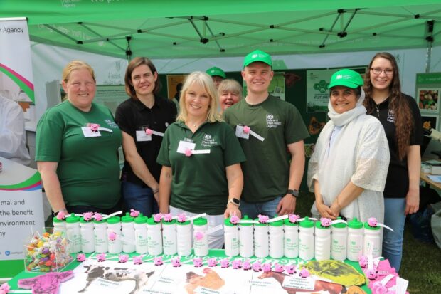 Group of APHA staff standing in a gazebo with some APHA merchandise