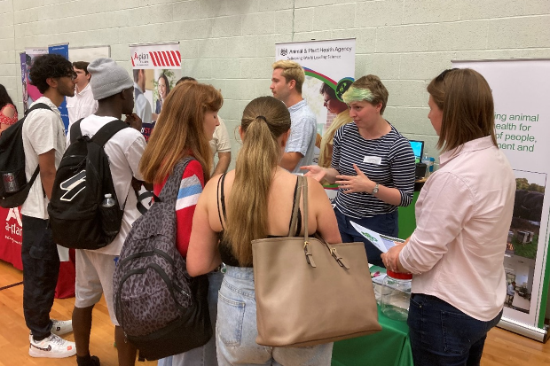 Image of a female chatting to students