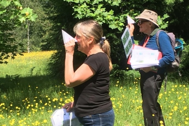 Male and female holding papers and triangular set squares to their eye