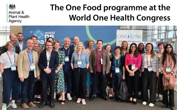 Group of professionals standing for a photograph in front of One Food banners