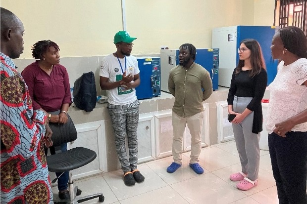 Group of six individuals chatting in a laboratory