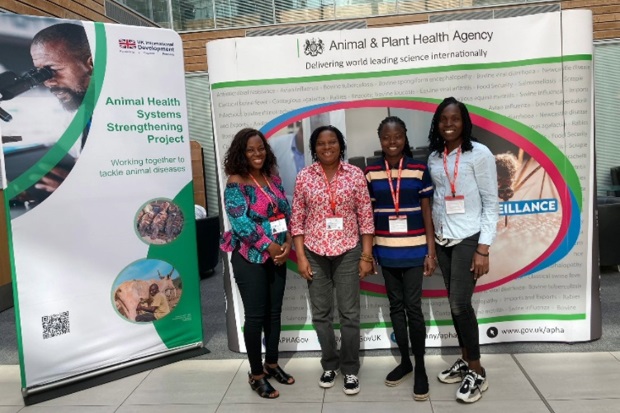 Four females standing in front of two large APHA posters